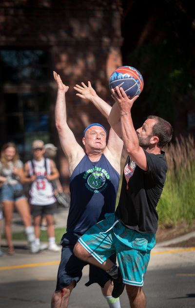 Jeff Taylor, left, tries to block a shot by Tony Kopp during the Hoopfest 3-on-3 basketball tournament in downtown Spokane on Saturday, June 29, 2019. Taylor and other players on his Hoopfest team, Against the Grain, are formerly homeless. (Colin Mulvany / The Spokesman-Review)