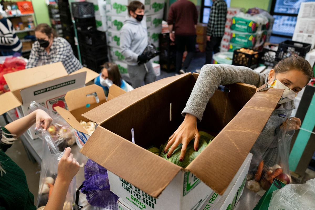 Volunteers package and distribute food for those in need at the New York Common Pantry on 109th Street, Wednesday, Dec. 1, 2021, in the Manhattan borough of New York. (John Minchillo)