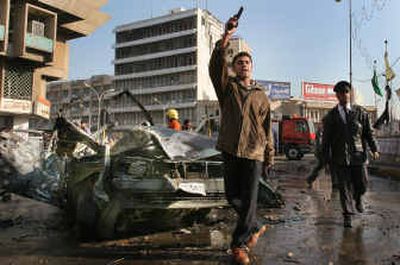 
A policeman shoots into the air to move bystanders from the scene of the blast. 
 (Associated Press / The Spokesman-Review)