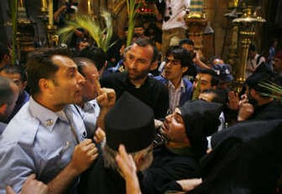 
An Israeli police officer tries to break up a fight Sunday between Greek and Armenian clergymen during processions for Orthodox Holy Week at the Church of the Holy Sepulcher  in Jerusalem. Associated Press
 (Associated Press / The Spokesman-Review)