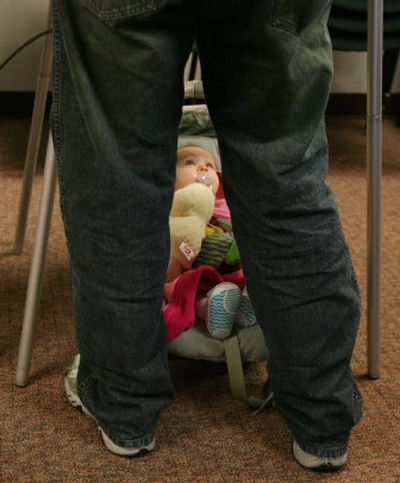 
Gwen Nelson, 8 months, looks at her father, Greg Nelson, as he casts his vote Tuesday morning in Meridian, Idaho. 
 (Associated Press / The Spokesman-Review)