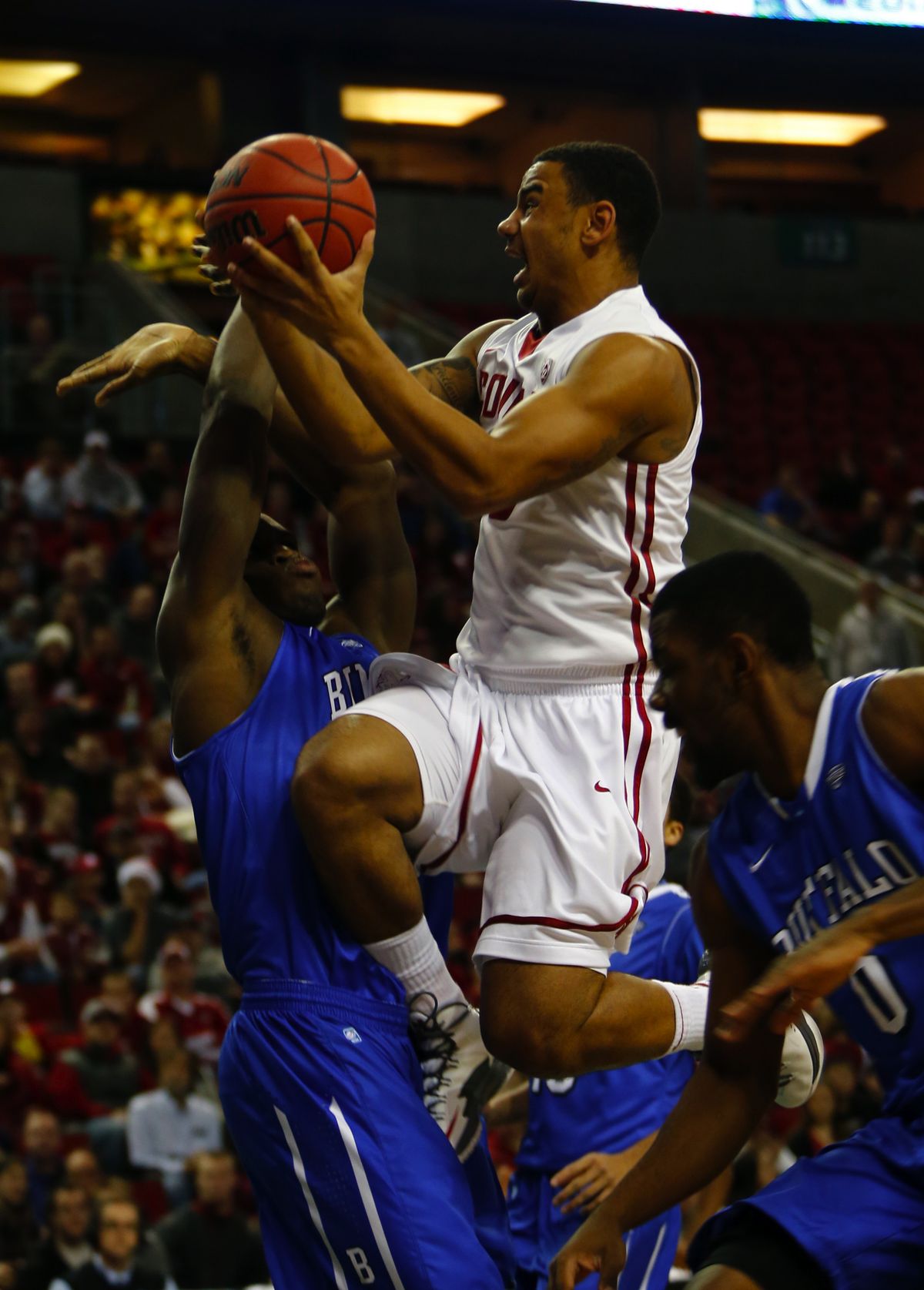 DaVonte Lacy soars between two Bulls defenders during Friday night’s game at KeyArena in Seattle. (Ellen M. Banner)