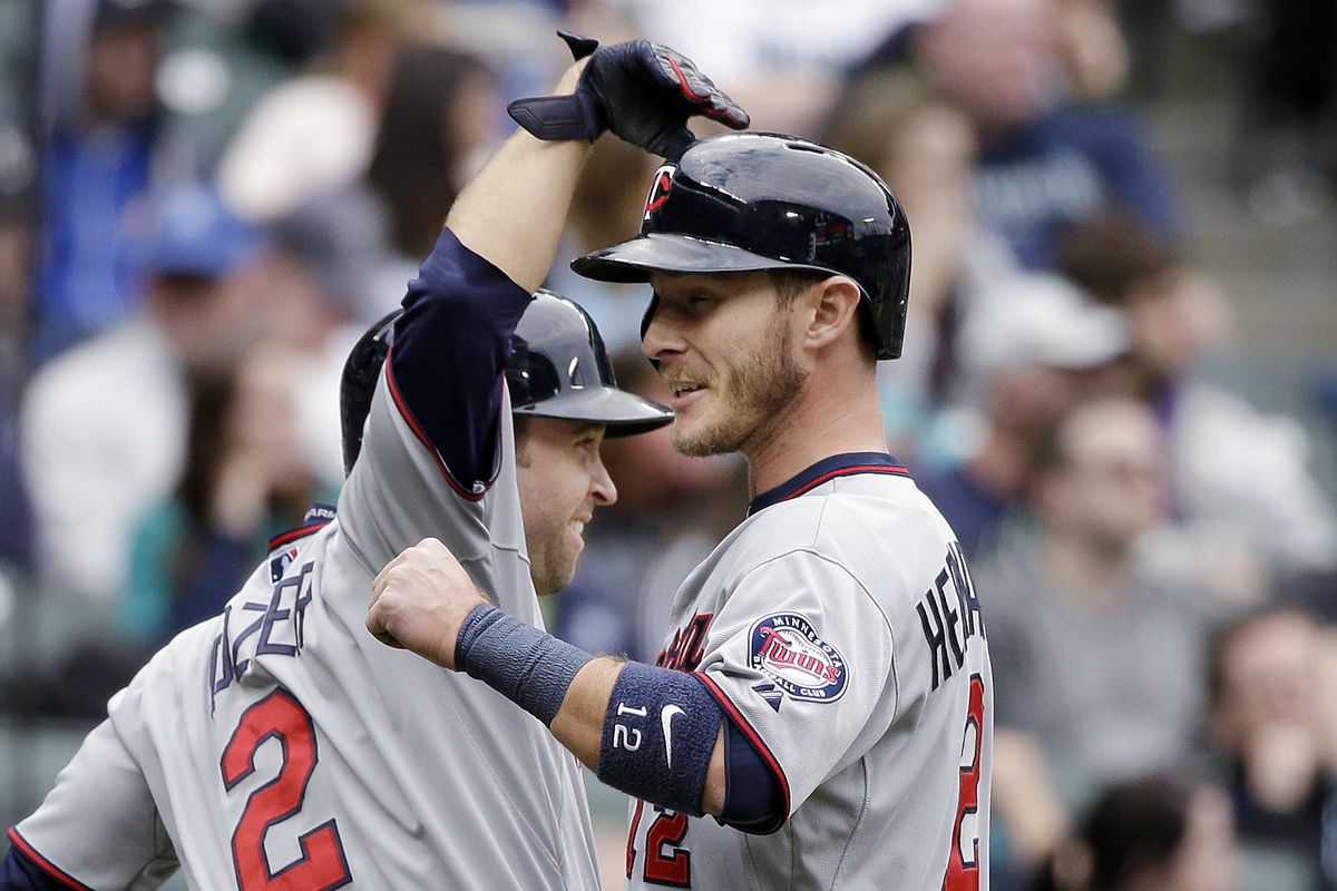 Brian Dozier and Chris Herrmann of the Twins celebrate after the two scored in the 11th inning on Joe Mauer’s triple off Tyler Olson. (Associated Press)