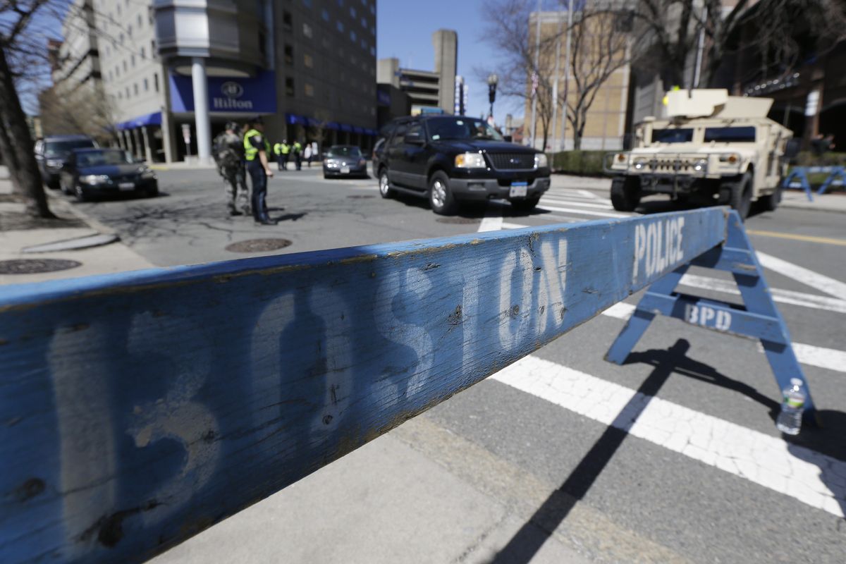 Officials stand guard near the site of the Boston Marathon explosions, Wednesday, April 17, 2013, in Boston. Authorities investigating the deadly bombings have recovered a piece of circuit board that they believe was part of one of the explosive devices, and also found the lid of a pressure cooker that apparently was catapulted onto the roof of a nearby building, an official said Wednesday. (Julio Cortez / Associated Press)