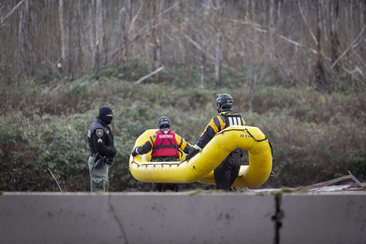 Search and rescue crews continue to look Thursday for a missing woman whose car was swept away by a mudslide Wednesday in the Dodson area of the Columbia River Gorge, in Oregon. Searchers used inflatable yellow rafts and drove metal poles into deep mud as they searched for the women.  (Associated Press)