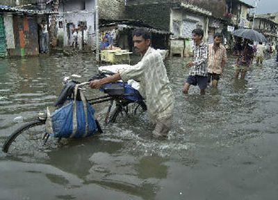 
A bread vendor goes through a flooded street in Bombay, India, on Sunday. 
 (Associated Press / The Spokesman-Review)