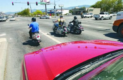 Scooter rider Brandan Stern waits at the light at Sprague and Evergreen in Spokane Valley along with other drivers, including motorcyclists from Idaho.
(J. BART RAYNIAK / The Spokesman-Review)