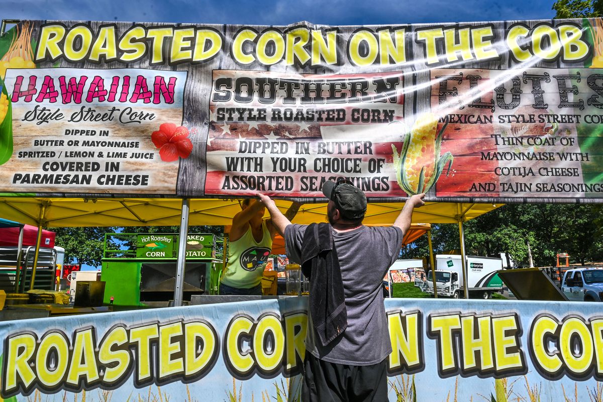 Bryan Hickey adds a little muscle to straighten a panel into position while helping to set up a roasted corn booth located near The Great Northern Clocktower for the 41st Pig Out in the Park in this August 2022 photo.   (Dan Pelle/The Spokesman-Review)