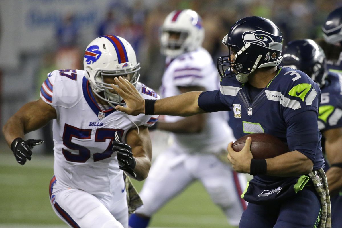 Seahawks quarterback Russell Wilson gives Buffalo Bills outside linebacker Lorenzo Alexander a stiff arm. (Elaine Thompson / Associated Press)