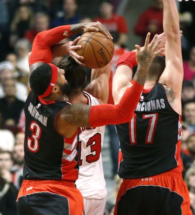 Toronto’s James Johnson, left, fouls Chicago’s Joakim Noah on a failed block attempt during first-half action on Monday. (Associated Press)