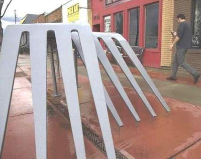 A man walks by ‘Forks in the Road,’ a public sculpture on Fourth Street in midtown Coeur d’Alene. The sculpture has been damaged by motorists, and fixed by the city, a few times since it was installed. (Lisa James/Coeur d'Alene Press photo)