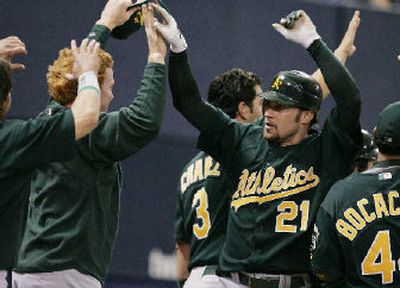 
Oakland teammates congratulate Mark Kotsay (21) after his inside-the-park homer in the seventh. 
 (Associated Press / The Spokesman-Review)