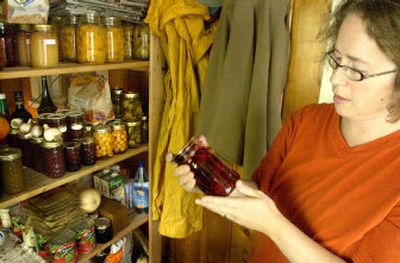 
5 Carol Price Spurling inspects a jar of pickled beets from her shelf of other recently canned items, which includes applesauce, sweet pickles, plums, Rainier cherries, peaches, pears and a variety of jams and jellies. 
 (Photos by BRIAN IMMEL / The Spokesman-Review)
