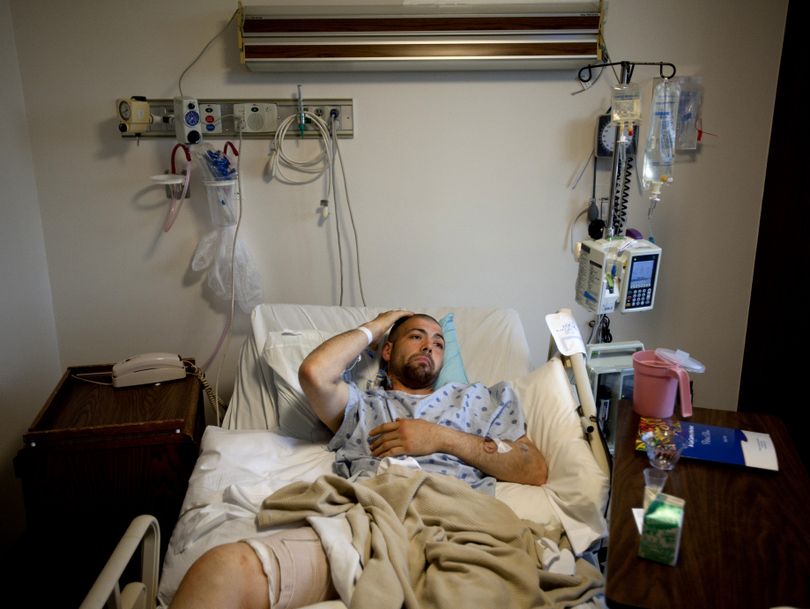 Jesse Hugh Johnson scratches his head as he lies with a bandaged thigh in a hospital bed on Monday at Providence Sacred Heart Medical Center in Spokane. Johnson was shot in the leg by a Spokane police officer while armed with what turned out to be a BB gun. (Tyler Tjomsland)