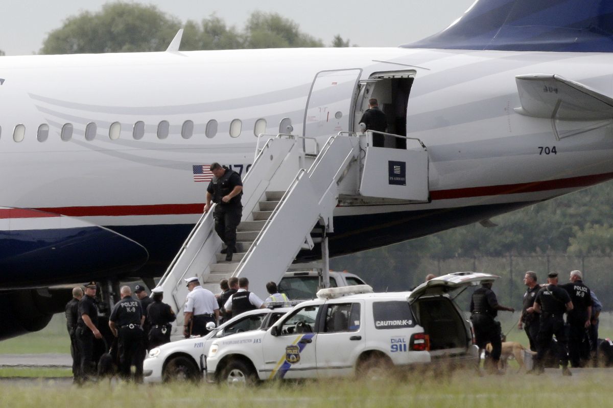 Law enforcement officials work around a US Airways flight at Philadelphia International Airport, after the plane returned to the airport, Thursday, Sept. 6, 2012, in Philadelphia. A security scare that prompted authorities to recall an airborne U.S. flight was the result of an apparent hoax, police said Thursday. (Matt Rourke / Associated Press)