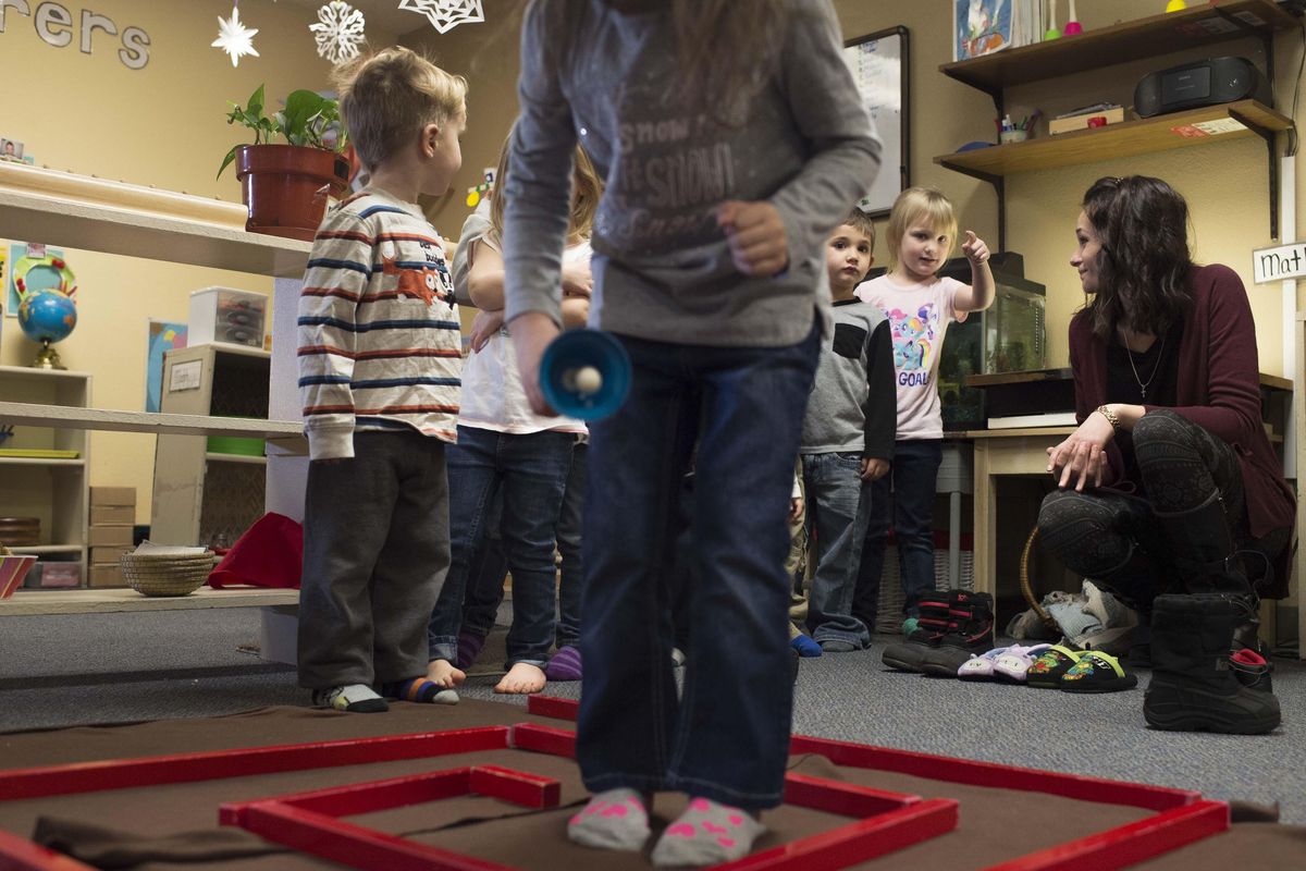 Preschool teacher Jen Wienckoski, right, talks with student Ender Michalski, second from right, as her students navigate a sensory activity Friday at Children’s Montessori Center in Spokane Valley. School owner Debbie Henry says Washington’s higher minimum wage is forcing her to raise her rates. (Tyler Tjomsland / The Spokesman-Review)