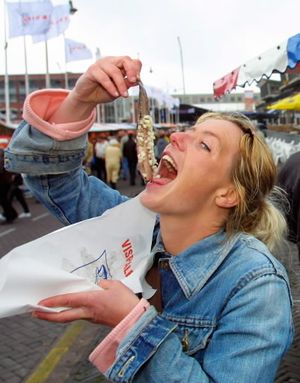Dutch woman Mira Wiersma eats a herring the traditional way in Scheveningen, the Netherlands. (AP file photo, for illustrative purposes)