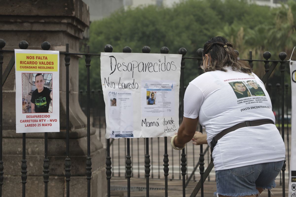 A family member of Ricardo Valdes, who disappeared on the road on May 25, places missing posters during a protest in Monterrey, Nuevo Leon state, Mexico, on Thursday. (Roberto Martinez)