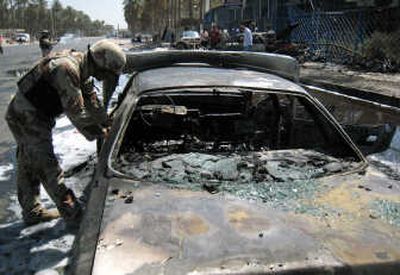 
An Iraqi soldier inspects the wreckage after a car bomb attack near the Shiite Buratha mosque in northern Baghdad on Monday. The attacked killed two civilians and wounded six others. Associated Press
 (Associated Press / The Spokesman-Review)