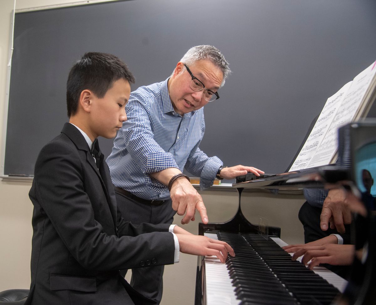 Alvin Chow gives tips to Matthew Huang, 11, about Tchaikovsky’s “Juin Baccarolle,” which Huang performed Monday at MusicFest, a weeklong music festival at Gonzaga University that focuses mainly on classical music. Hundreds of young musicians, singers and dancers took part Monday. One highlight of the event is the participation of highly skilled and educated adjudicators, with each giving extensive personal feedback to performers.  (Jesse Tinsley/THE SPOKESMAN-REVIEW)