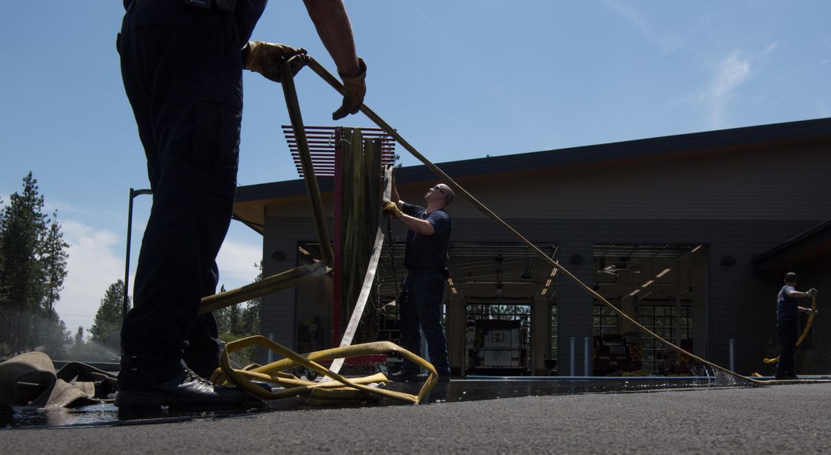 Lt. Kurt Vandervert with Stevens County Fire District 1 works to hang washed hoses at District 1’s new Suncrest station on Friday, July 6, 2018, in Nine Mile Falls, Wash. The new station features a large paved back area that allows crews to wash equipment. (Tyler Tjomsland / The Spokesman-Review)