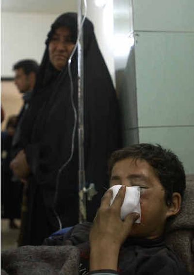 
An Iraqi boy waits to be treated Saturday in Yarmook hospital after being wounded by a roadside bomb that killed one and injured two Iraqis in the Dorah distict in Baghdad.
 (Associated Press / The Spokesman-Review)