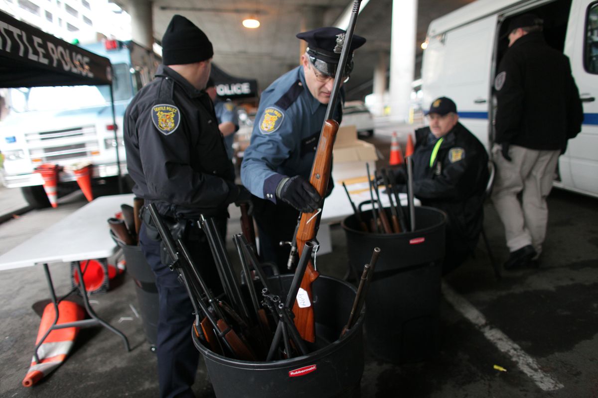 Seattle police officers log guns exchanged for gift cards during a city gun buyback program held beneath Interstate 5 on Saturday. (Joshua Trujillo)