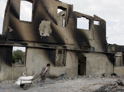 A woman walks past a destroyed building in Tskhinvali,  South Ossetia, on Saturday.  (Associated Press / The Spokesman-Review)