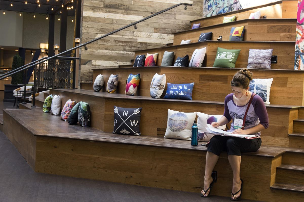 In the lobby of the newly renovated Hotel RL by Red Lion, Andrea Falk, 19, sits in an area called The Steps, a place across from a community performance stage. The downtown hotel, along the north bank of the Spokane River, has been remade to be more inviting to guests and the community. (COLIN MULVANY colinm@spokesman.com / The Spokesman-Review)