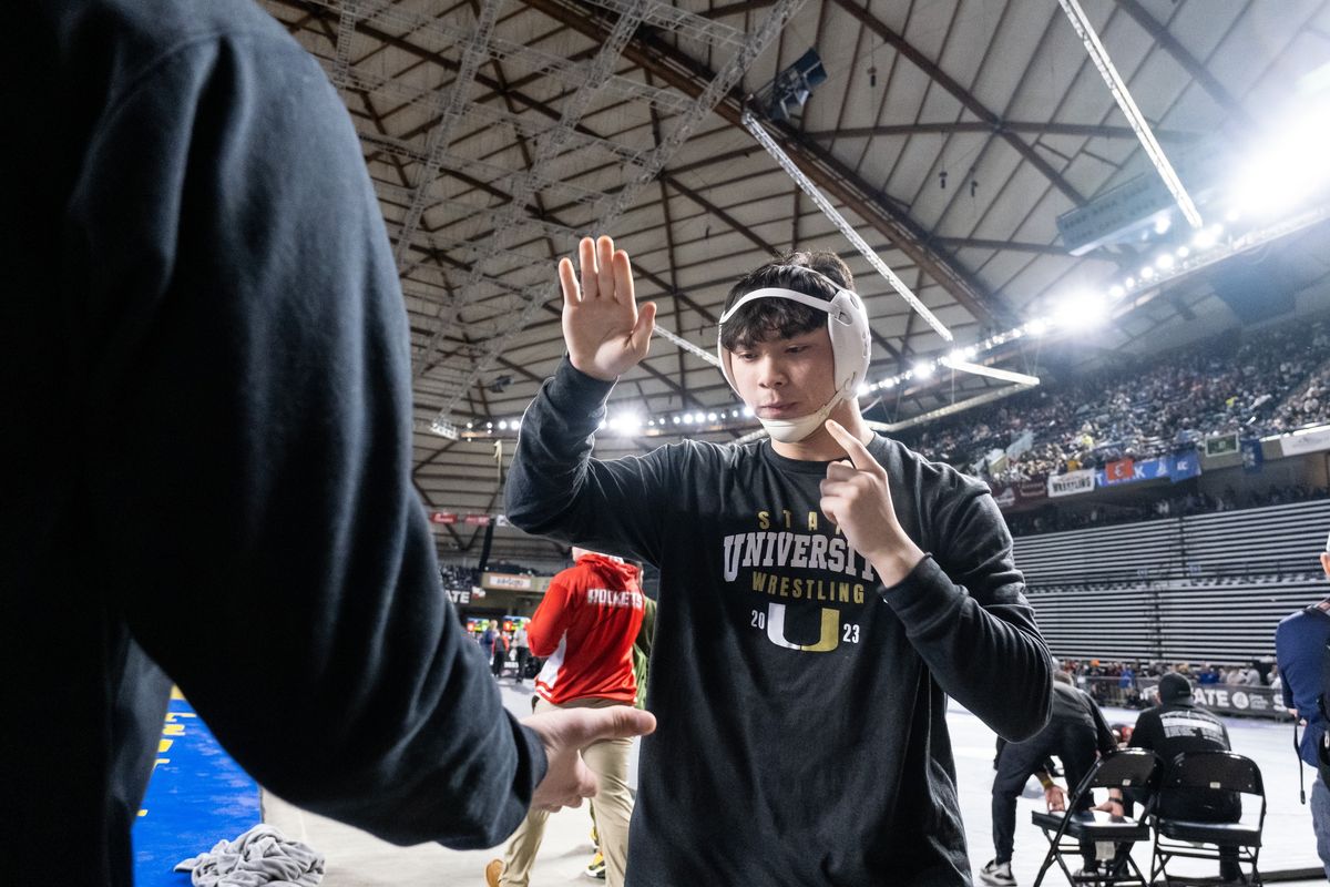 University’s Q’veli Quintanilla high fives a coach ahead of his State 3A second-round match at Mat Classic XXXIV on Friday in Tacoma. (Madison McCord/For The Spokesman-Review)