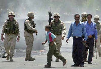 
A boy walks past U.S. Army soldiers and Iraqi police as they secure the area after an explosion destroyed a car near an entrance to the headquarters of the U.S.-led coalition in central Baghdad, Iraq, on Monday.A boy walks past U.S. Army soldiers and Iraqi police as they secure the area after an explosion destroyed a car near an entrance to the headquarters of the U.S.-led coalition in central Baghdad, Iraq, on Monday.
 (Associated PressAssociated Press / The Spokesman-Review)