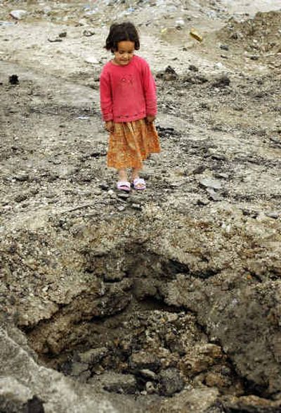 
Hayfaa, 4, looks at the crater left by a roadside bomb which targeted an Iraqi army convoy in the Doura area of Baghdad Thursday, in which a woman and child were injured, according to eyewitnesses. 
 (Associated Press / The Spokesman-Review)