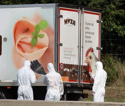 Investigators stand near a truck at the shoulder of highway A4 near Parndorf south of Vienna, where up to 50 migrants were found dead. (Associated Press)