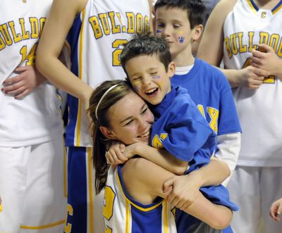 Rachel Johnson celebrates Colfax’s state title with coach Corey Baerlocher’s son, Cole. (Dan Pelle / The Spokesman-Review)