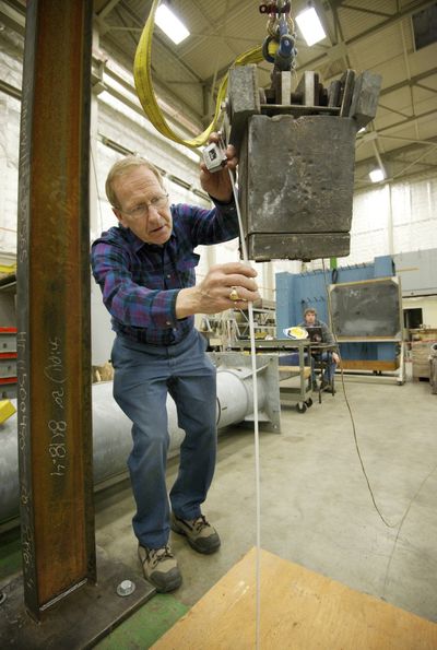Engineer Mick Johnson measures distance before testing the strength of a metal clip intended to keep workers from falling from utility towers. (Associated Press)