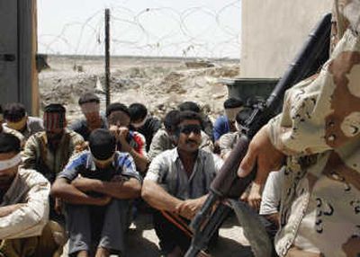 
An Iraqi soldier guards arrested suspected al-Qaida members in Baqouba, 35 miles northeast of Baghdad, on Monday.Associated Press
 (Associated Press / The Spokesman-Review)