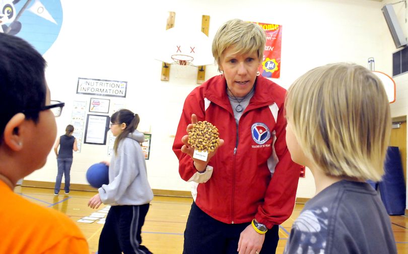 PE teacher PJ Jarvis, center, explains where black-eyed peas fall in the food groups during a nutrition lesson at Opportunity Elementary School. Jarvis was selected as the elementary school teacher of the year by the National Association for Sport and Physical Education. (Jesse Tinsley)
