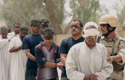 
Iraqi Army soldiers escort blindfolded suspects during a raid Sunday in Muqdadiyah, Iraq. 
 (Associated Press / The Spokesman-Review)