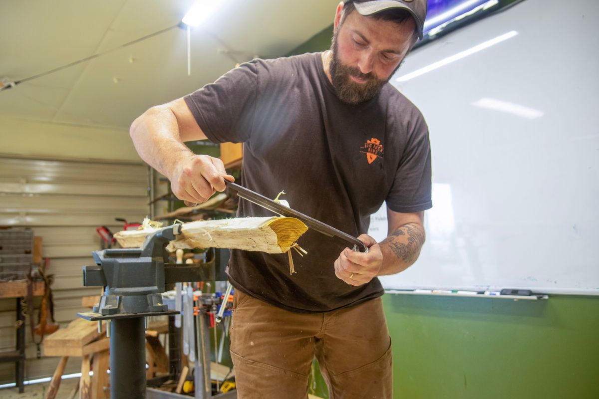 David Young shaves wood off a bow stave in his shop south of Spokane on Thursday, June 25, 2026. (Michael Wright/The Spokesman-Review)