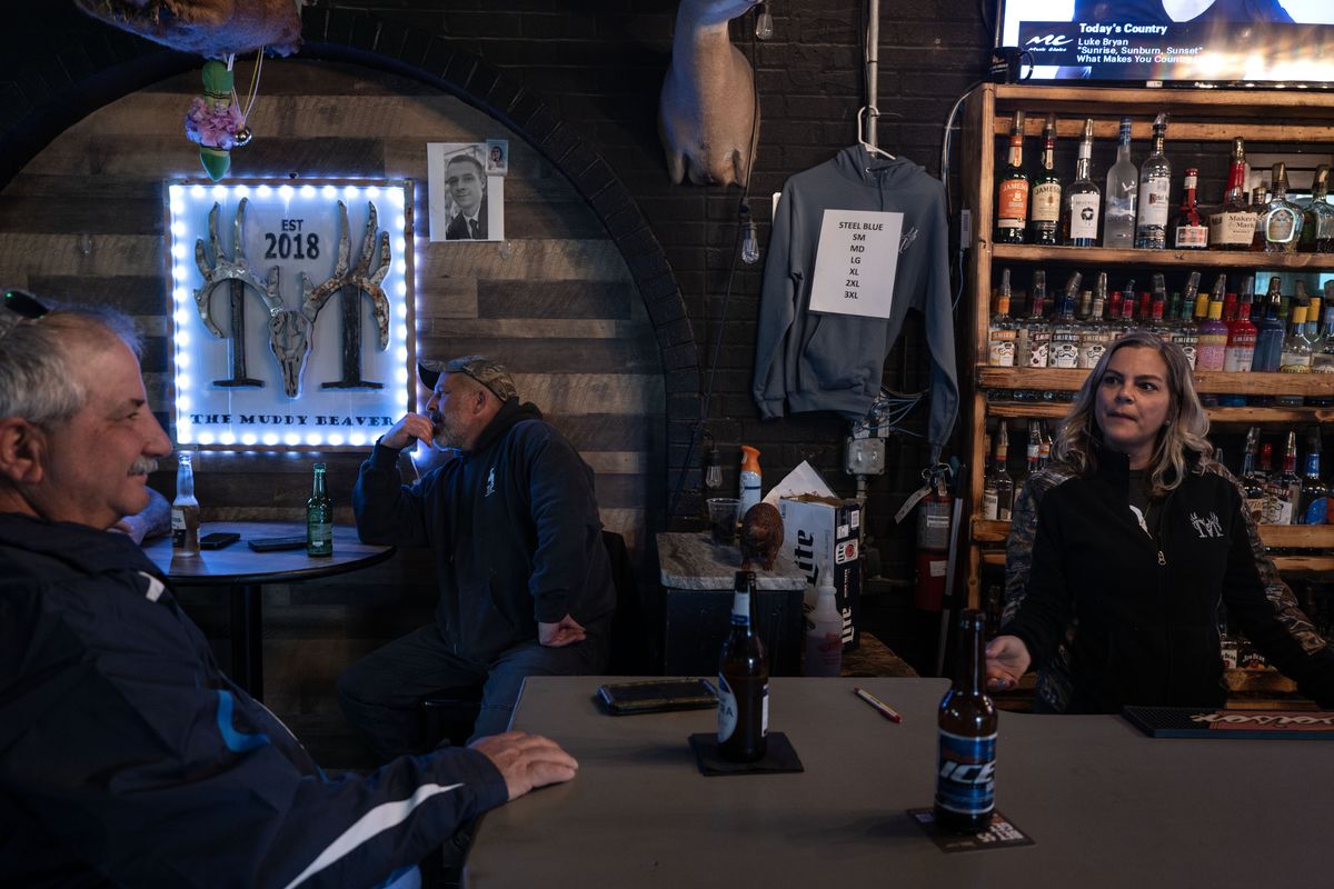 Bartender Melissa Hayes, right, talks with tugboat captain Dino Martinez, left, at the Muddy Beaver, a bar in Sparrows Point, Md.  (Michael Robinson Chávez/For the Washington Post)