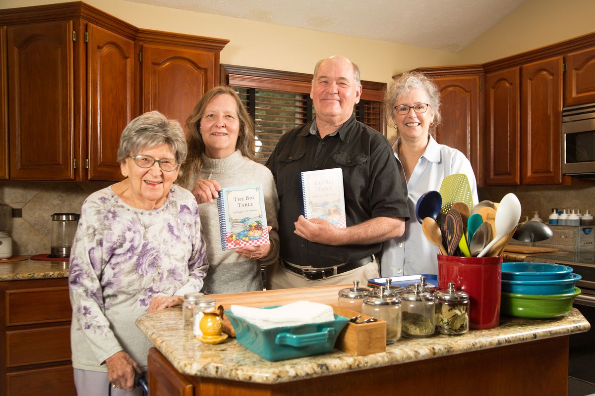 The McHugh family, from left, matriarch Barbara, daughter Megan, son Pat and daughter-in-law Kass, are photographed in the household kitchen with copies of their cookbook, “The Big Table: 350 Recipes-100 Families,” on Nov. 9 in Spokane. Pat McHugh spearheaded the cookbook project filled with family favorites.  (Libby Kamrowski/ THE SPOKESMAN-REVIEW)