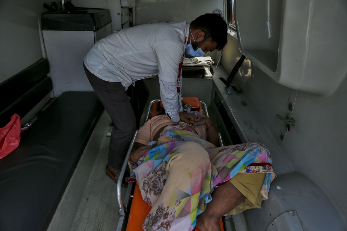 A health worker gives cardiopulmonary resuscitation (CPR) to a COVID-19 patient waiting to be attended to inside an ambulance outside a government COVID-19 hospital in Ahmedabad, India, Tuesday, April 27, 2021. The COVID-19 death toll in India has topped 200,000 as the country endures its darkest chapter of the pandemic yet.  (Ajit Solanki)