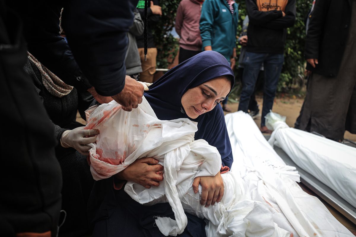 Relatives of the Palestinians who lost their lives mourn in front of the Nasser Medical Hospital morgue in Khan Younis on Tuesday after a school was struck.    (Loay Ayyoub/for The Washington Post)