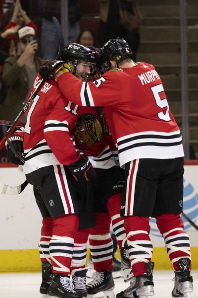 Blackhawks center Tyler Johnson is swarmed by teammates after scoring the tying goal against the Kraken during the third period Sunday, Oct. 23, 2022, at the United Center.  (Chicago Tribune)