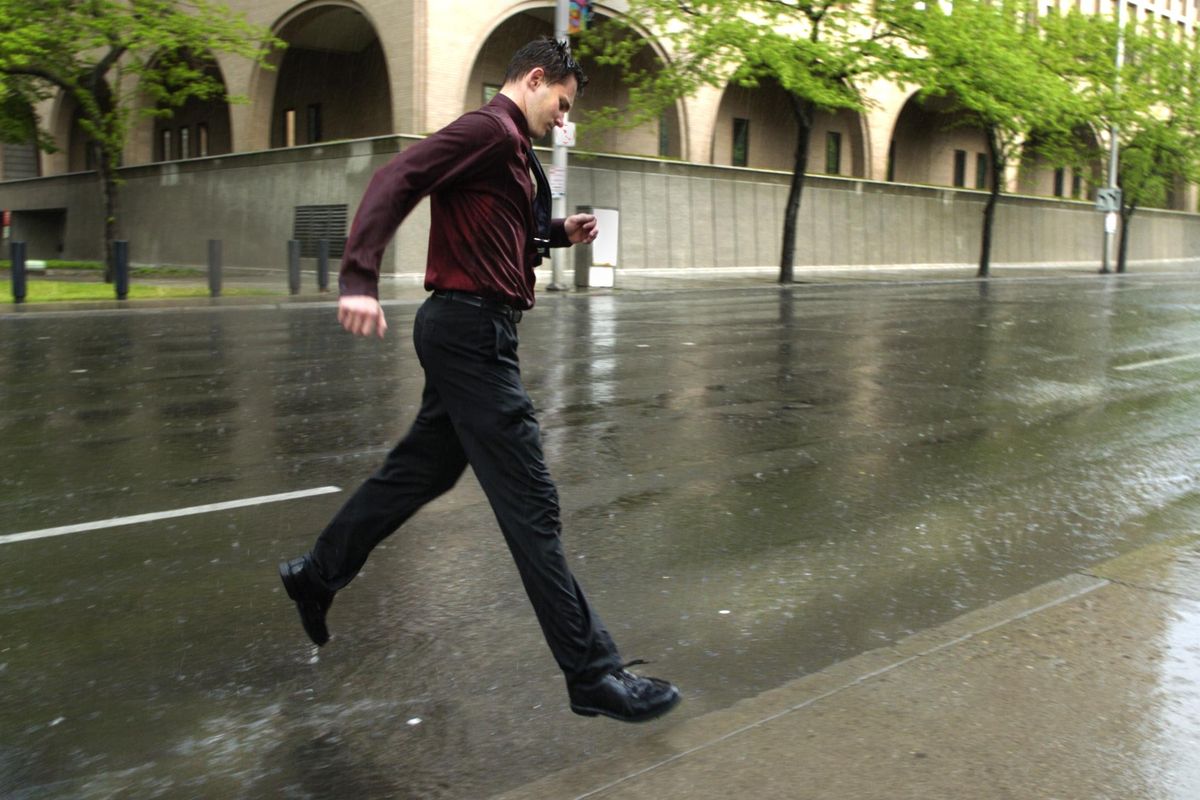 “This is better than 92 degrees, “ said Josh Butela who was caught in a thunderstorm as he walked home from work Friday afternoon, May 19, 2006, in downtown Spokane. (Colin Mulvany / The Spokesman-Review)