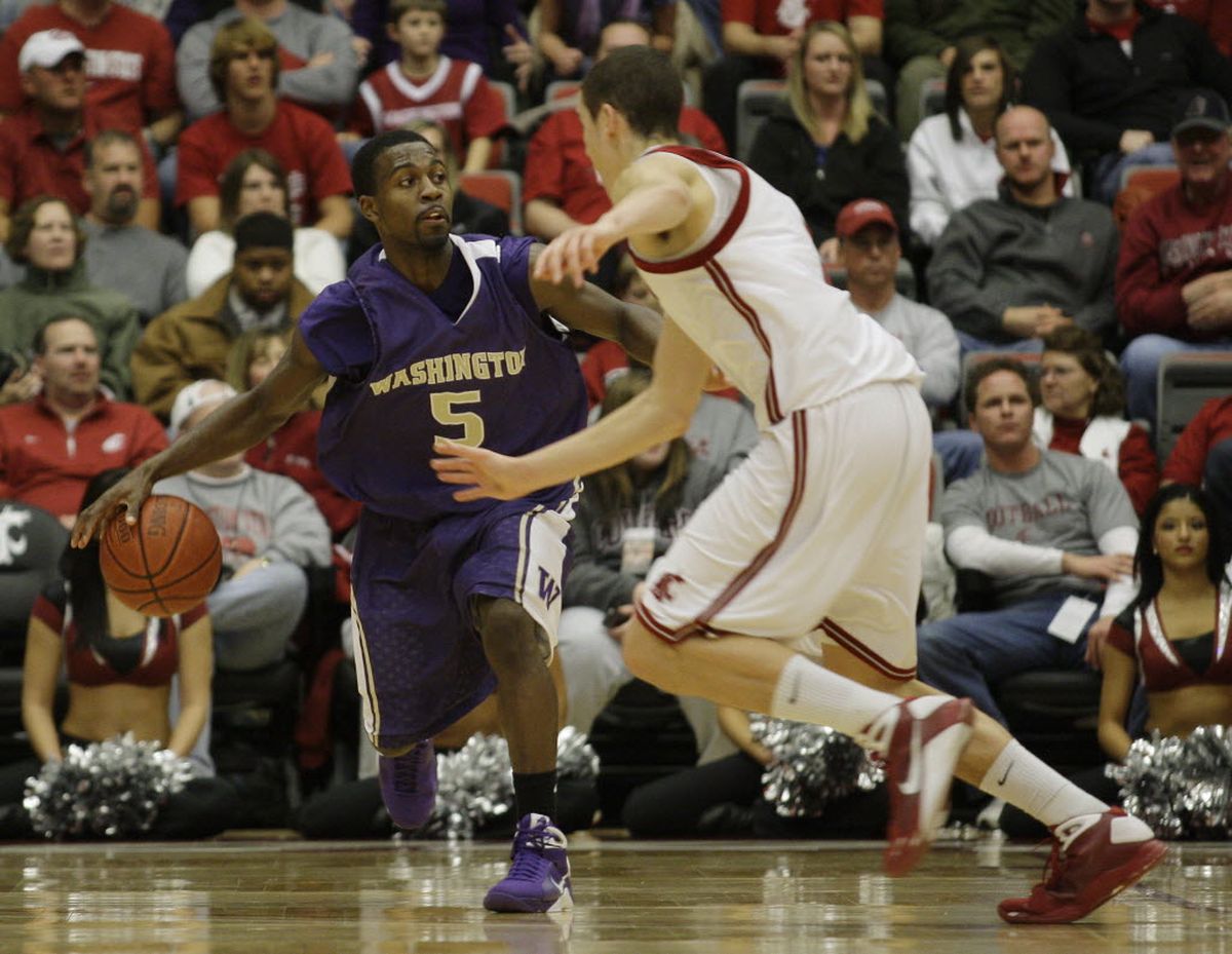 Washington guard Justin Dentmon (5) drives past Washington State guard Klay Thompson in the second half of an NCAA college basketball game today at Friel Court in Pullman, Wash. Washington beat Washington state 68-48.   (Ted S. Warren / The Associated Press)