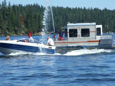 
A passing boat is doused with water by the pontoon manned by members of the Newman Lake Volunteer Fire Department during the annual boat parade on the lake July 4.
 (Tom Detwiller / The Spokesman-Review)