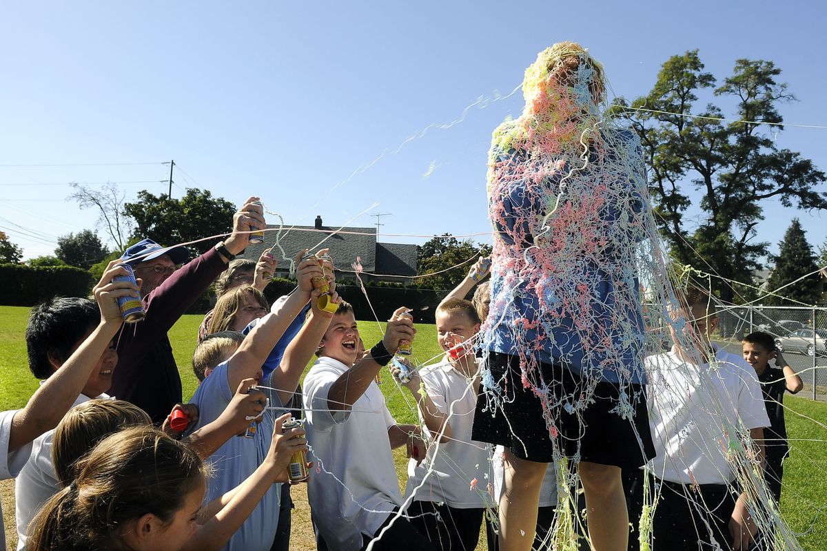 Trinity Catholic School Principal Sandra Nokes gets blasted with canned confetti string by seventh-graders after they  raised the most money schoolwide for the Scholastic Book Fair’s One for Books donation program. The school collected $730.danp@spokesman.com (Dan Pelle / The Spokesman-Review)