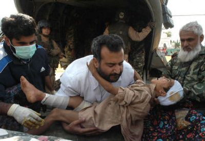 
Injured Pakistani earthquake survivors are rushed to a U.S. military helicopter on Tuesday from a stadium in Muzaffarabad, capital of Pakistani Kashmir.
 (Associated Press / The Spokesman-Review)