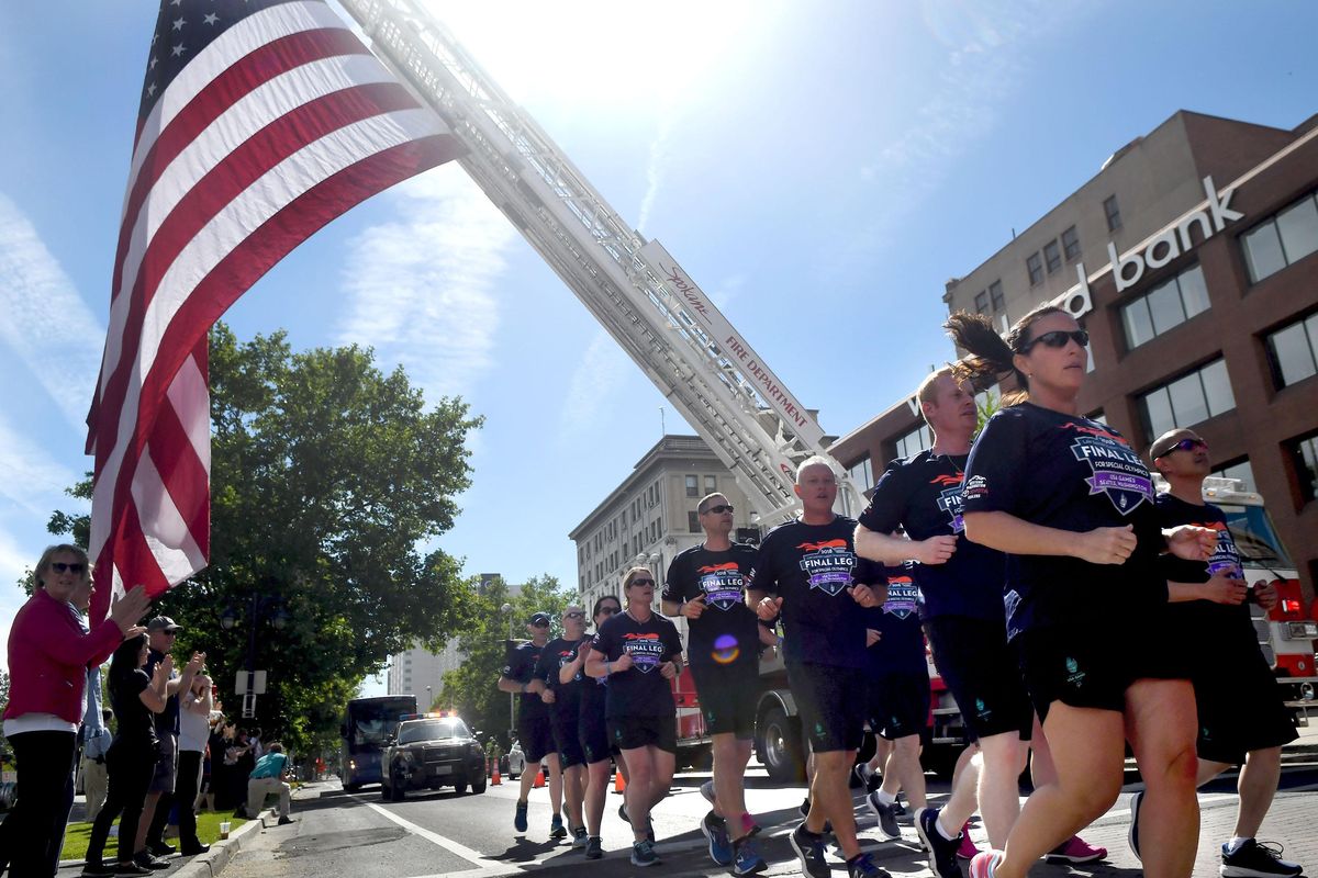 Law enforcement officers from across the country and Special Olympics athletes carry the 2018 Special Olympics Flame of Hope through Spokane as part of the final leg of the Law Enforcement Torch Run  on Wednesday, June 27, 2018. (Kathy Plonka / The Spokesman-Review)